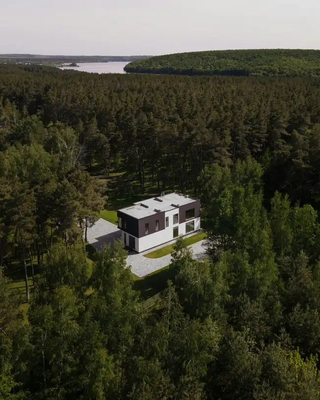 Moderni omakotitalo metsän ja järven ympäröimänä
